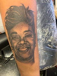 a tattoo of a woman with a smile on her arm