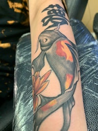 a koi fish tattoo on the forearm