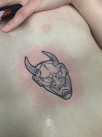 a tattoo of a demon on a woman's stomach