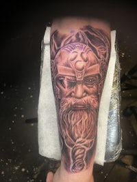 a tattoo of a viking on the forearm