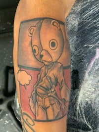 a tattoo of a teddy bear on a person's arm