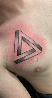 a man with a triangle tattoo on his chest