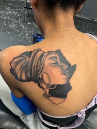 a woman with an african tattoo on her back