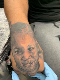 a tattoo of a child's face on a person's hand