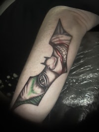 a joker tattoo on a man's arm